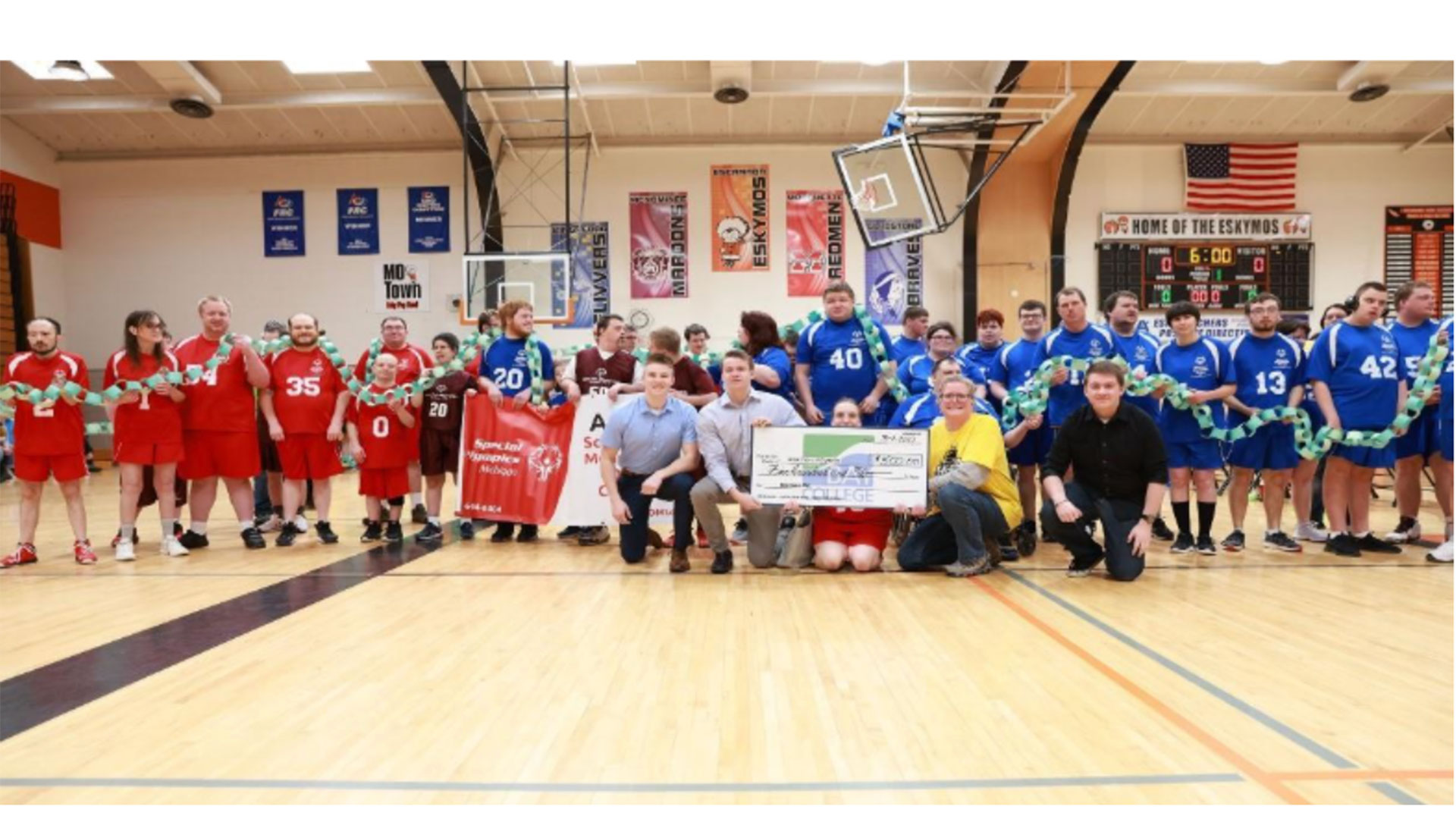 BPA students and Local Area 1 Special Olympics participants gather in the gym in 2025 with a giant check displaying funds raised for this special program.