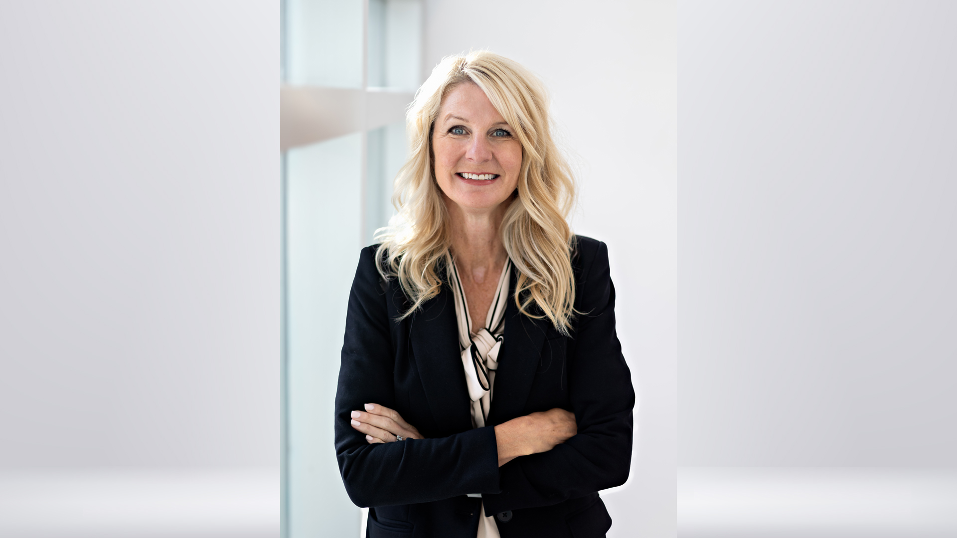 Vice President of Workforce Innovation & Strategic Partnerships Cindy Gallagher smiling in a dark suit jacket beside a sunlit window.