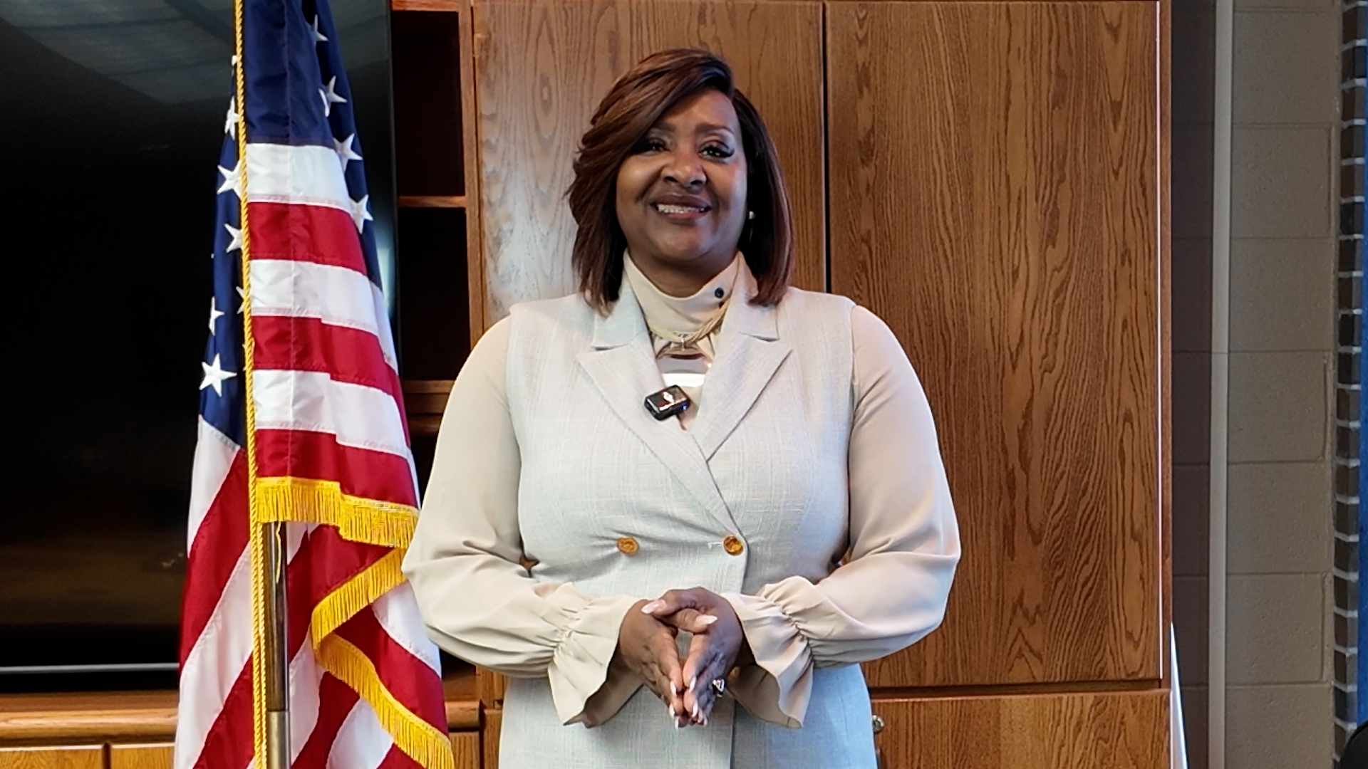 Bay College President Dr. Nerita Hughes speaking from the Bay College board room beside the American flag.