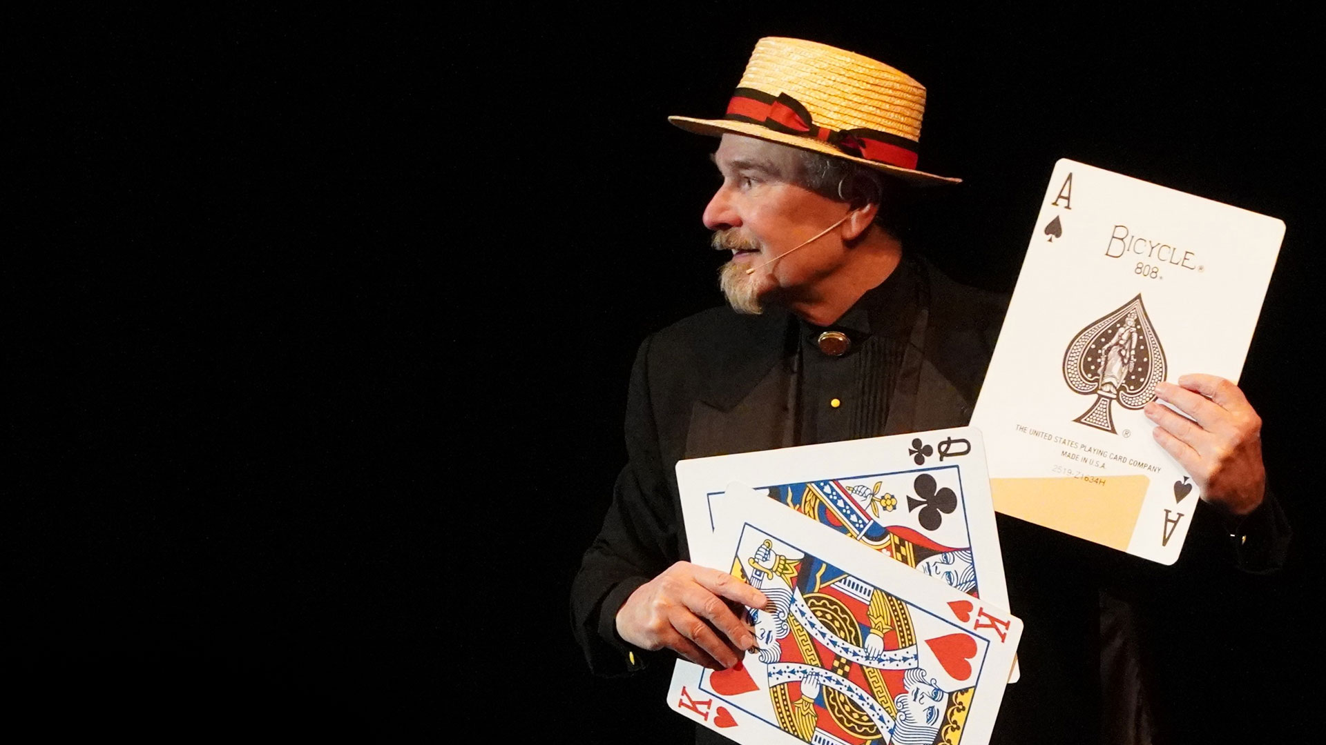  Award-winning magician Daryl Rogers on stage performing an illusion with giant playing cards.