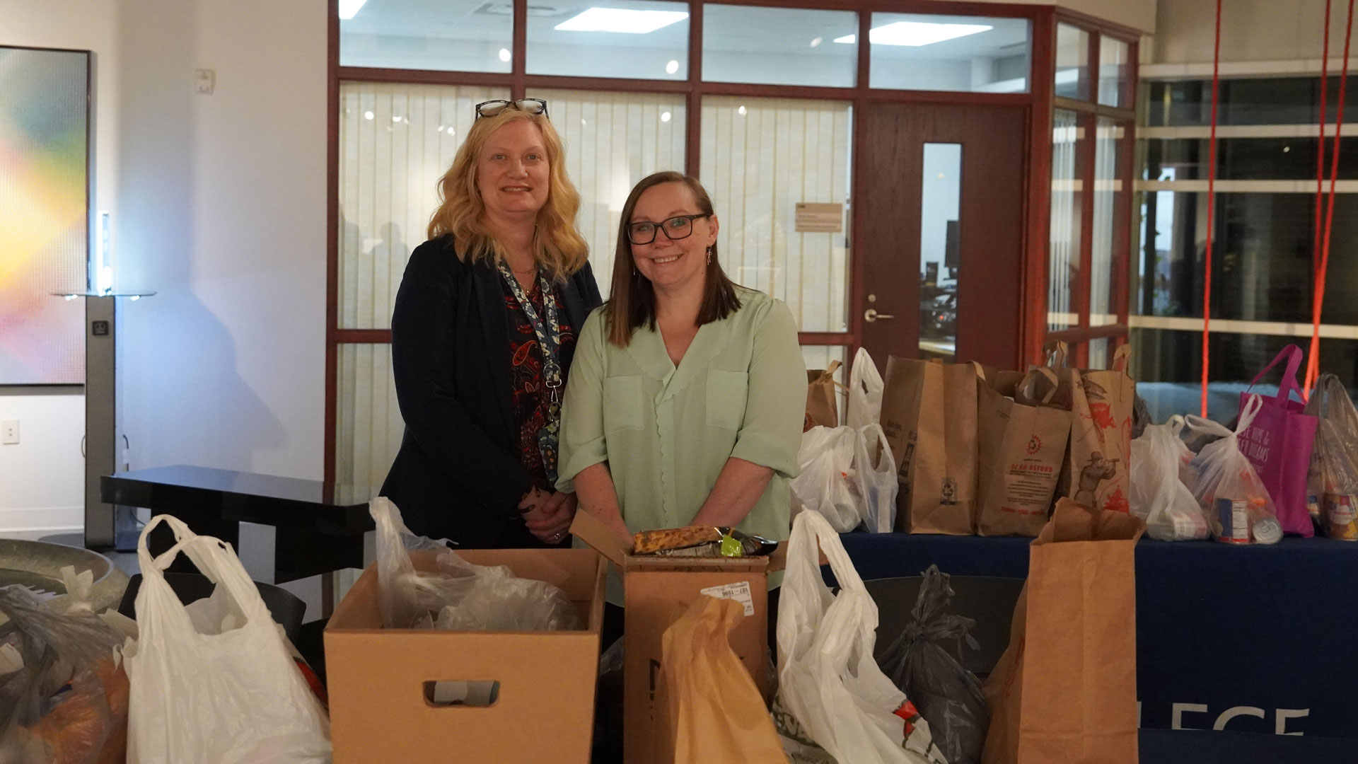 Bay College staff Deanna Robinette and Kari Meunier collect food pantry donations at the 2025 Day of Giving event.