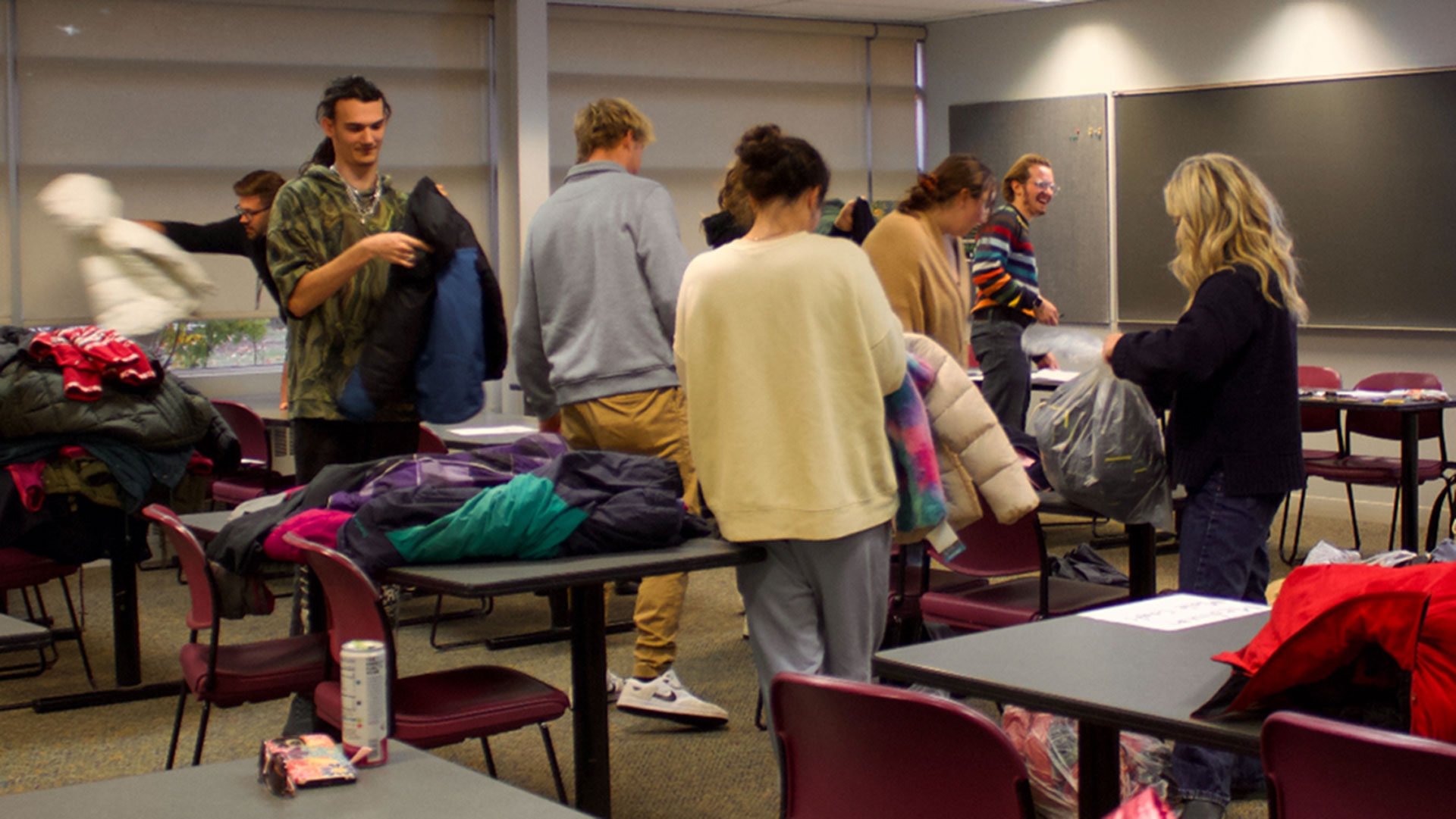 Students volunteering to organize and prepare donated winter coats and accessories for Delta County community members.
